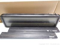 Three vintage rectangular black sign light bars laid out on a flat surface against a beige background, showing brand 'Simon' on two smaller bars.