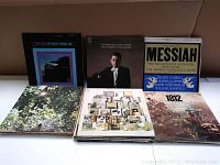 Photo shows seven vinyl LP records with various cover art including classical and historical themes.