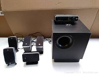 Logitech speakers and subwoofer with control console displayed on top of subwoofer.