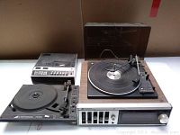 Wide photo showing all three audio components on a white surface against a brown background: Toshiba unit with turntable, Electrohome turntable, and Panasonic tape deck.