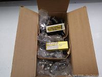 Open cardboard box filled with multiple vacuum tubes, some in original Sylvania and Realistic Lifetime boxes, wrapped in plastic bags