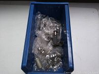 Blue storage bin containing multiple vintage glass vacuum tubes wrapped in bubble wrap, viewed from above.