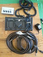 Lot containing Realistic 4 Channel Stereo Microphone Mixer, Behringer headphone amplifier, and instrument cables on a wooden floor.