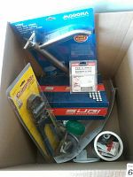 Photo of plumbing tool kit box containing CrimpRite Combo Tool, Modona cold water tap, tub and wall sealer, various plumbing fittings and supplies.