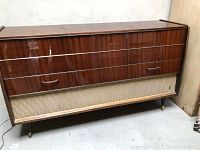 Closed walnut veneer console showing front panel, chrome trim and tapered legs