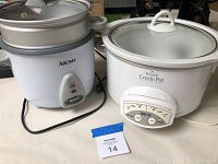 Photo of Rival Crock-Pot slow cooker and Aroma rice cooker placed side by side showing both appliances and the lot number.