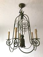 Front and side views of vintage green patina iron chandelier with five candle lights plus additional one facing downwards in center, hanging from chain.