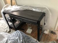 Full view of the office desk showing the wood top, iron frame, side shelves, and drawer underneath.