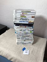 Stack of 25 Nintendo Wii game cases showing spines with game titles.