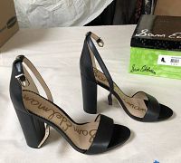 Pair of brand new black suede women's heels with block heels and ankle straps displayed with original box.