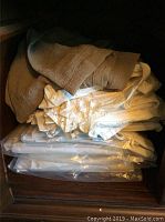 Stack of assorted window treatments and panels, some folded, some packaged.