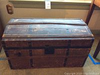 Front view of wooden trunk showing exterior condition and overall shape.