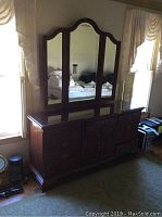 Front view of Jamestown Sterling wooden dresser with mirror, showing dark wood finish, tempered glass top, and triple mirror with curved edges.