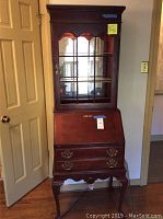 Full front view of two-piece wooden secretary desk with curio hutch