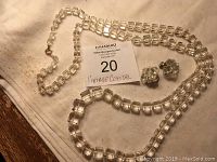 Photo showing a vintage crystal bead necklace with square cut beads and a pair of matching clip-on earrings.