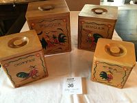 Front view of four wooden vintage canisters labeled Flour, Sugar, Coffee, and Tea with colorful rooster artwork.