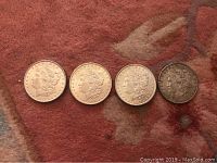Front view of four Morgan silver dollars