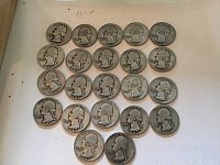 Photo showing 22 silver quarters dated 1943 arranged on a white background highlighting the obverse side with George Washington profile.