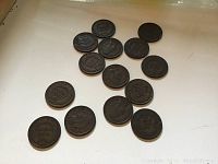 Fourteen Indian Head pennies laid out showing obverses and reverses, arranged on white background.