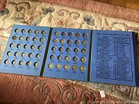 Full view of coin folder holding Mercury Head dimes from 1916 to 1936 with many empty slots.