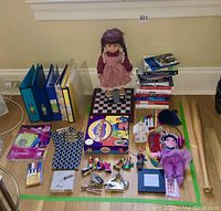 Photo showing the entire assortment of toys, dolls, board game, books, stationery, and wooden bat in a taped off area on floor.