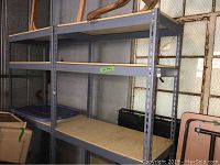 Front and side view of two metal garage racks with particle board shelves in garage storage setup.