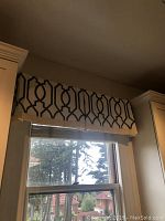 Photo showing one window valence with a black and white geometric pattern mounted above a window.