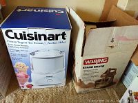 Photo of boxed Cuisinart Frozen Yogurt-Ice Cream & Sorbet Maker beside box labeled Waring Stand Mixer showing packaging condition.