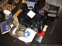 Saitek Pro Flight yoke system with buttons, headphones, Commander 2000 radio, and cables resting on a box with software manuals.