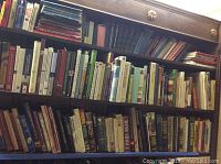 Books on wooden shelves including classic children’s literature titles and various educational topics.