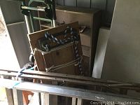 Photo showing 6ft aluminum ladder and 7ft wood ladder leaning against shelf with dollies and other items in background.