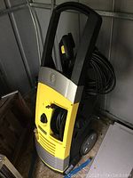 Front and side view of Karcher electric power washer showing the body design, large handle, and wheels for mobility.