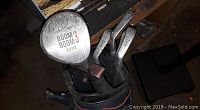 Top view of golf bag showing several Wilson Lynx irons and a 'Boom Boom 3' wood golf club