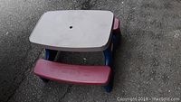 Front and top view of Step 2 child's fold-up picnic table showing gray tabletop, burgundy benches, and blue structural parts.