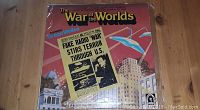 Front cover of The War of the Worlds record album showing colorful artwork and newspaper headline.