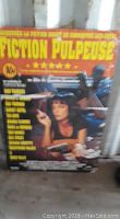 Photo of the Pulp Fiction movie poster within a hardwood display frame, showing the text and the central image clearly.