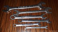 Photo showing six Craftsman wrenches of various sizes arranged on a wooden surface. The sizes visible include 3/4, 5/8, 9/16, 1/2 inches.