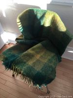 Green and yellow checked throw blanket draped over a chair, showing size and color.