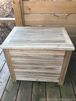 Exterior front and side view of slatted teak cooler chest on deck