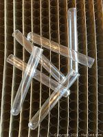 Close-up of several clear glass mini laboratory test tubes with rounded bottoms and smooth surface, arranged on top of the box section representing multiple tubes.