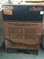Cardboard box of Aladdin portable kerosene heater Temp-Rite II 19,500 BTU model 3681M with visible branding and shipping information.