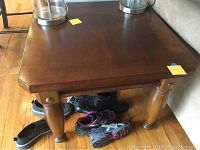 Close-up view of side table leg showing dark stained wood and brass detailing