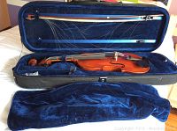 Dellafina Model 50 viola inside open hard case with blue velvet lining, horsehair bow secured in upper lid, blue velvet pouch beside case