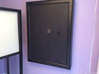 Front view of black rectangular wall mount jewelry box with chalkboard front, showing tape residue marks.