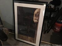 Full view of the framed Andrew Wyeth poster leaning against a wall. Shows framing and overall condition.