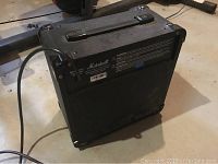 Backside view of Marshall Micro 40 watt amplifier showing carry handle and power cord attached