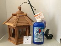 Bird feeder, clamp-on railing hook, and Feeder Fresh bottle viewed as a set