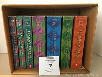 Photo showing the full set of seven Harry Potter paperback books in a box, spine view.