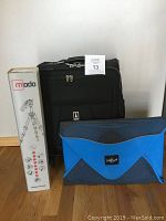 Photo showing the full lot with Travelpro suitcase, Eagle Creek shirt packer, and boxed Manfrotto Modo tripod.