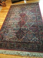 Full view of the oriental style rug showing overall pattern, colors, and fringe sides.